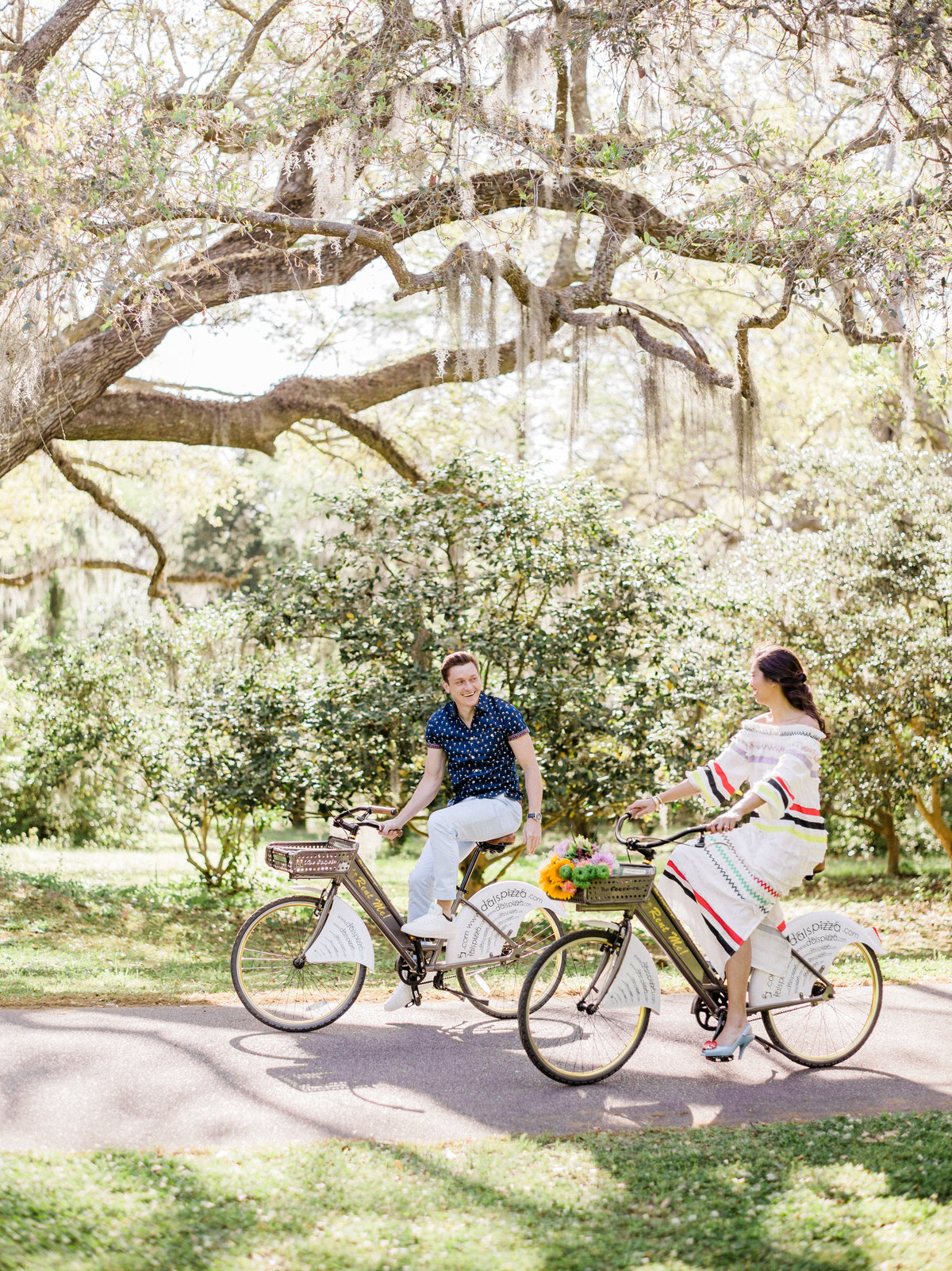 Cute couple riding bikes during engagement pictures at Charles Towne Landing.