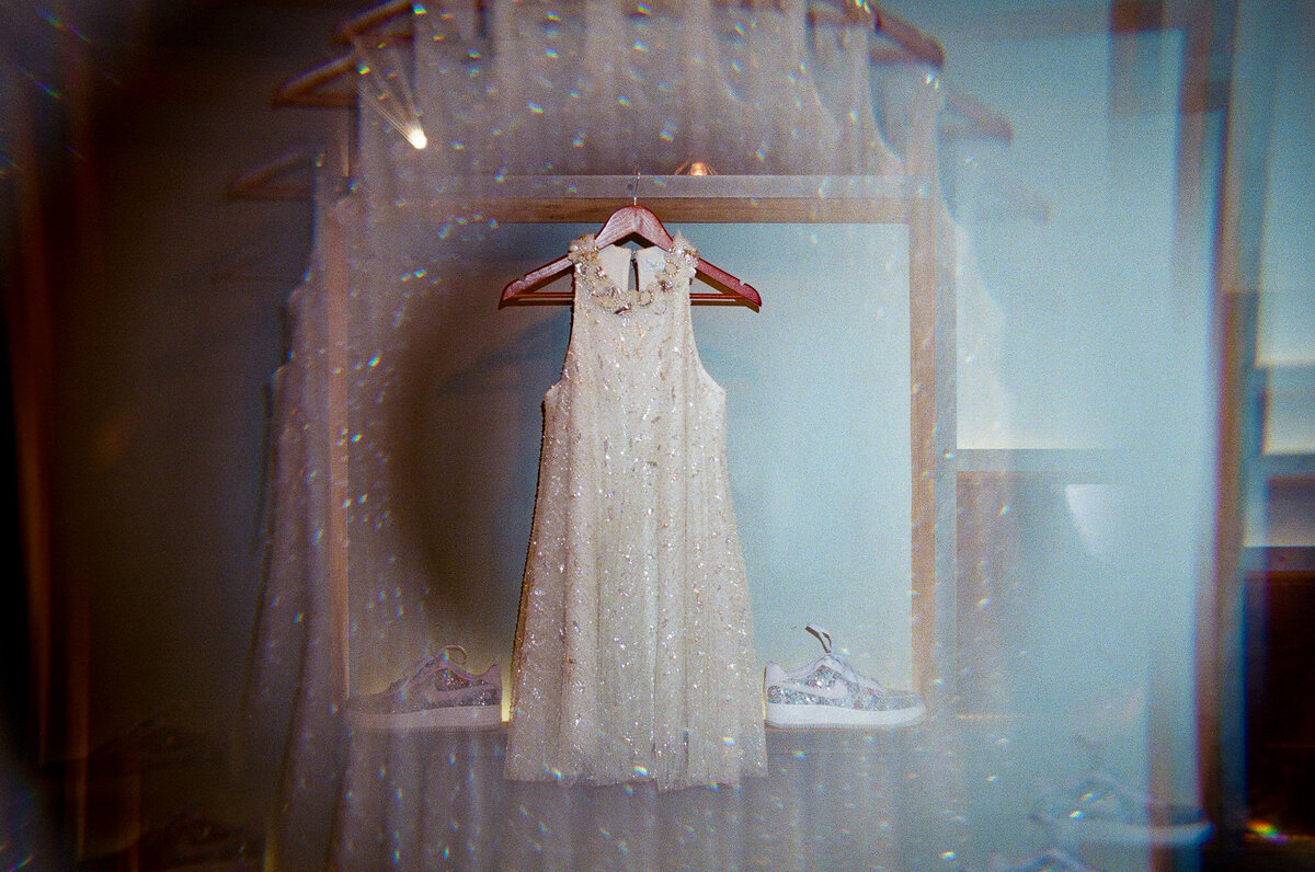 A wedding dress hanging up on a wall.