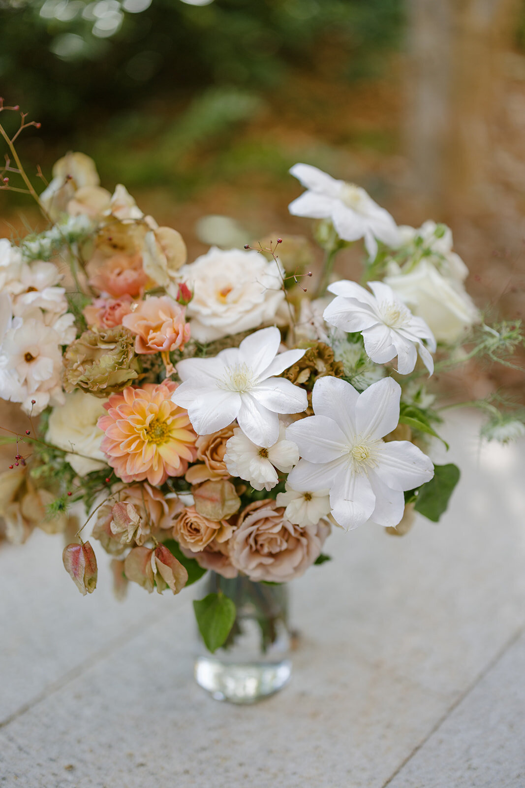 Fall bridal bouquet with lush autumnal colors of mauve, dusty pink, cream, white, peach, taupe, and green. Florals of dahlias, roses, clematis, lisianthus, and natural greenery. Fall wedding in Raleigh, NC. Design by Rosemary and Finch Floral Design in Nashville, TN.