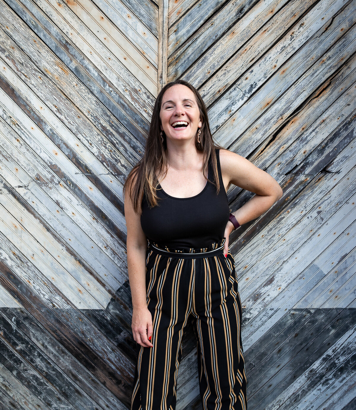 A woman laughs during her branding session in the industrial Clipper Mill area of Baltimore, Maryland