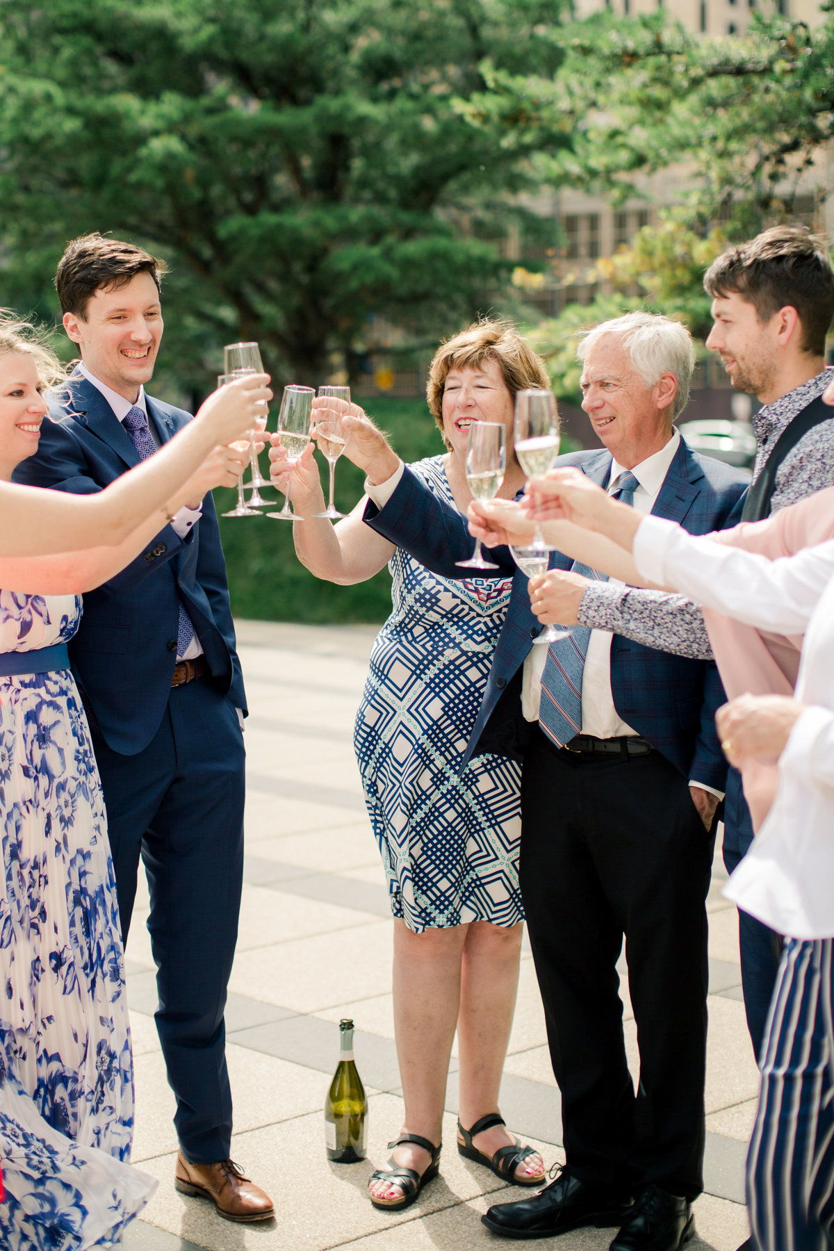 after elopement in downtown minneapolis immediate family cheers with bubbly outside