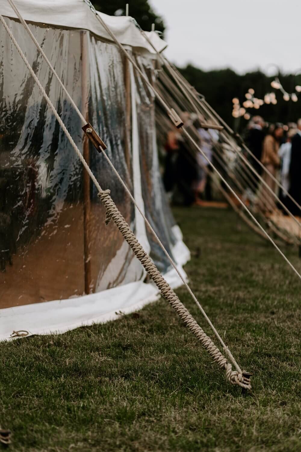 The outside of a pole marquee showing rope pining the maruqee to the ground