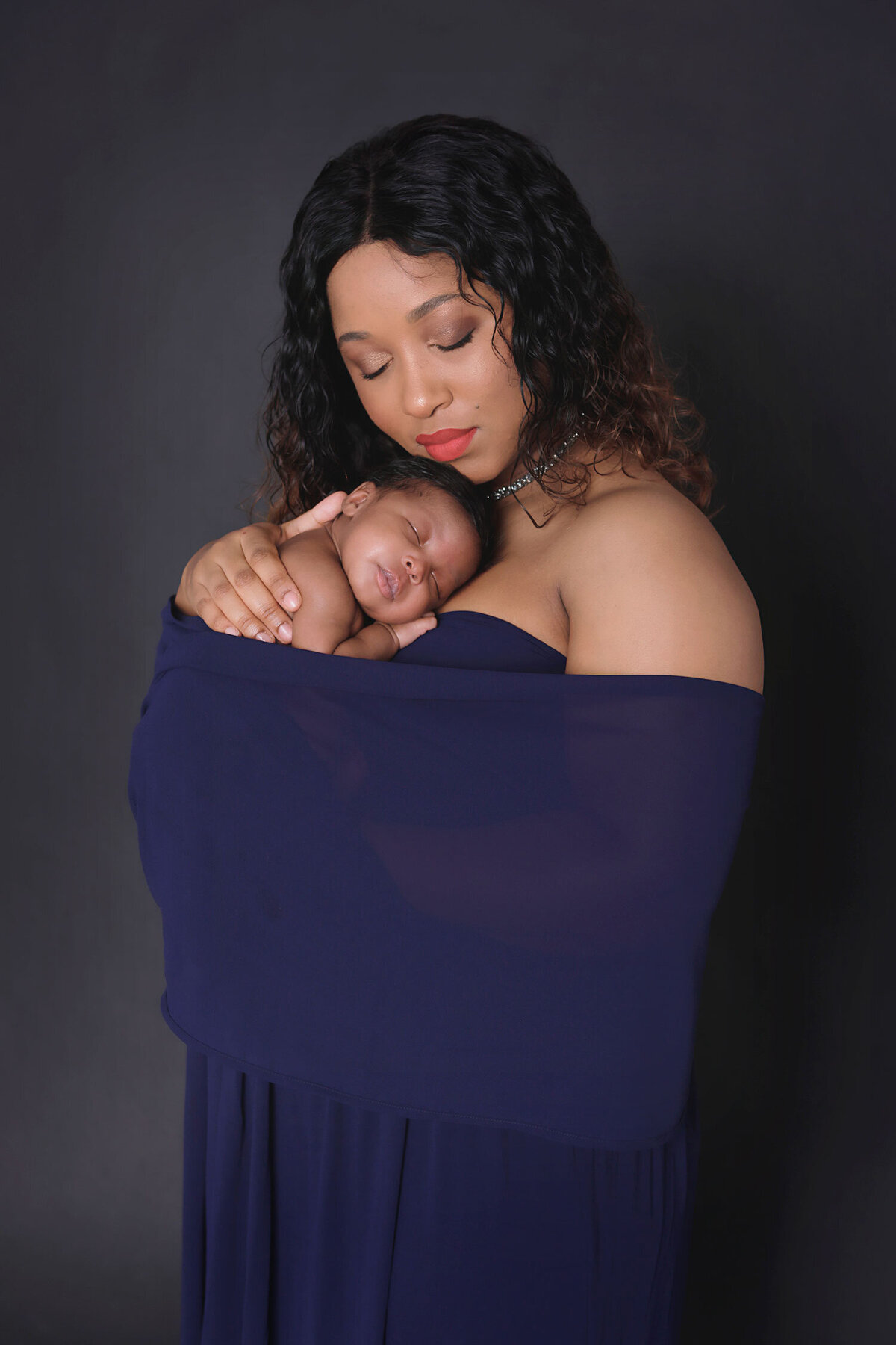 Newborn-boy-ten-day-old-sleeping-in-his-mommies-arms-for-his-newborn-photoshoot