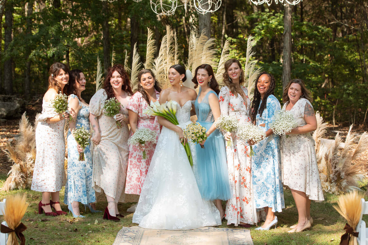 Bridesmaids in mistatched floral print pastel dresses.