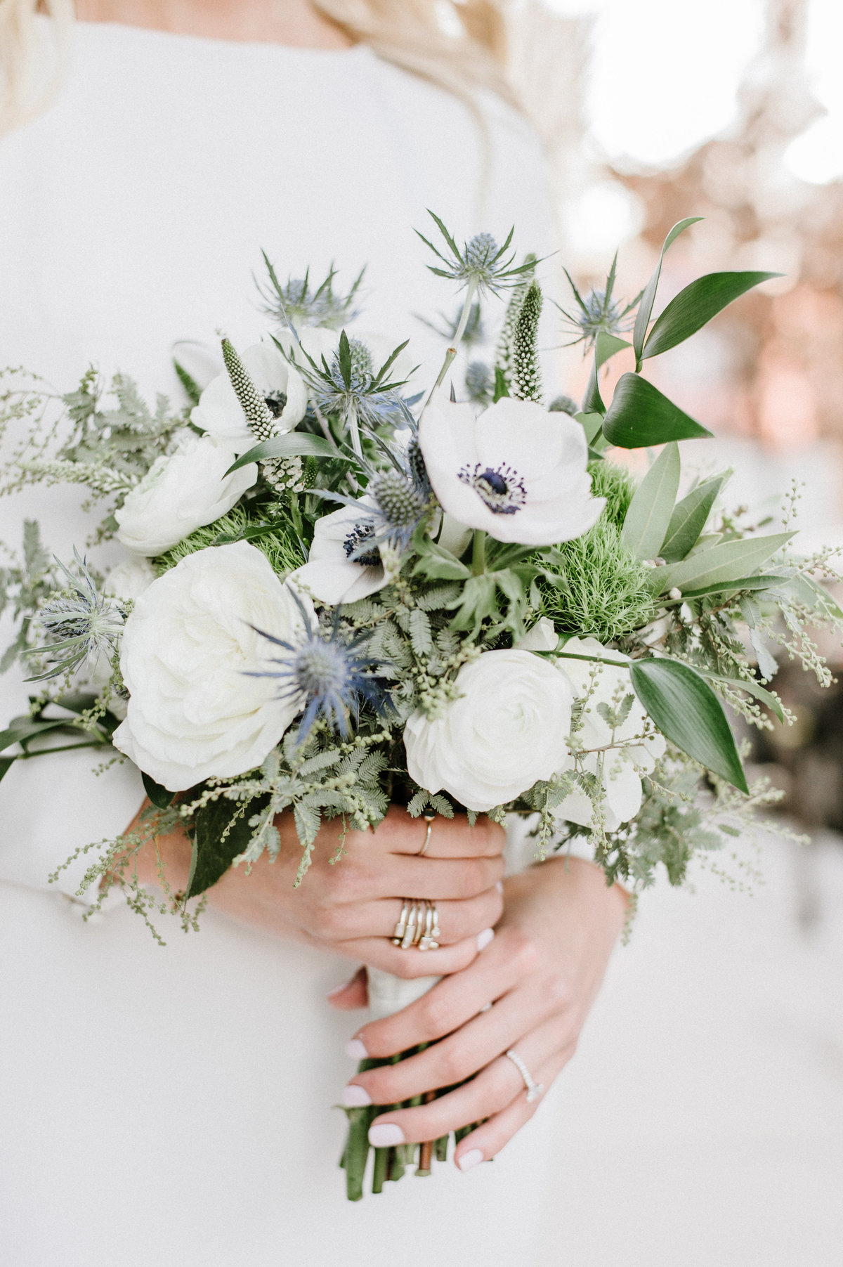 bride holding winter bouquet with blue and white flowers