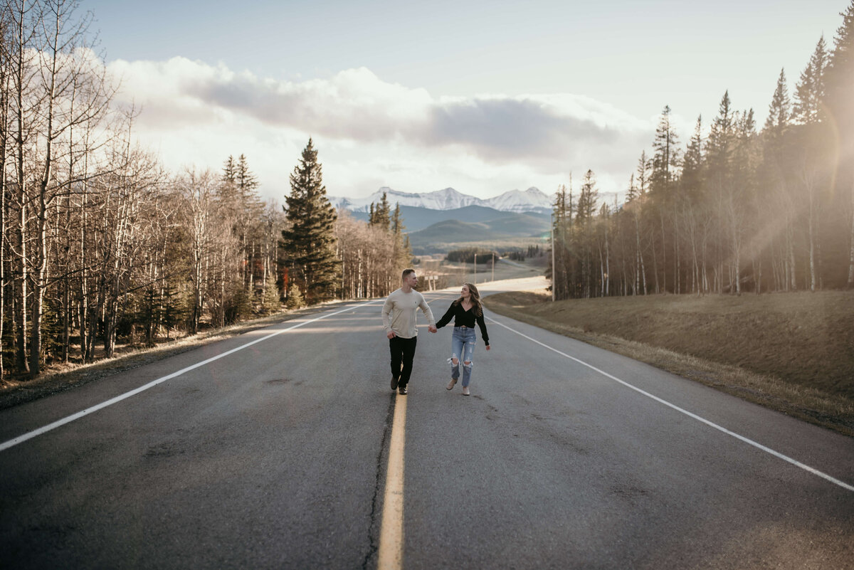 Man and woman run down a road in photoshoot