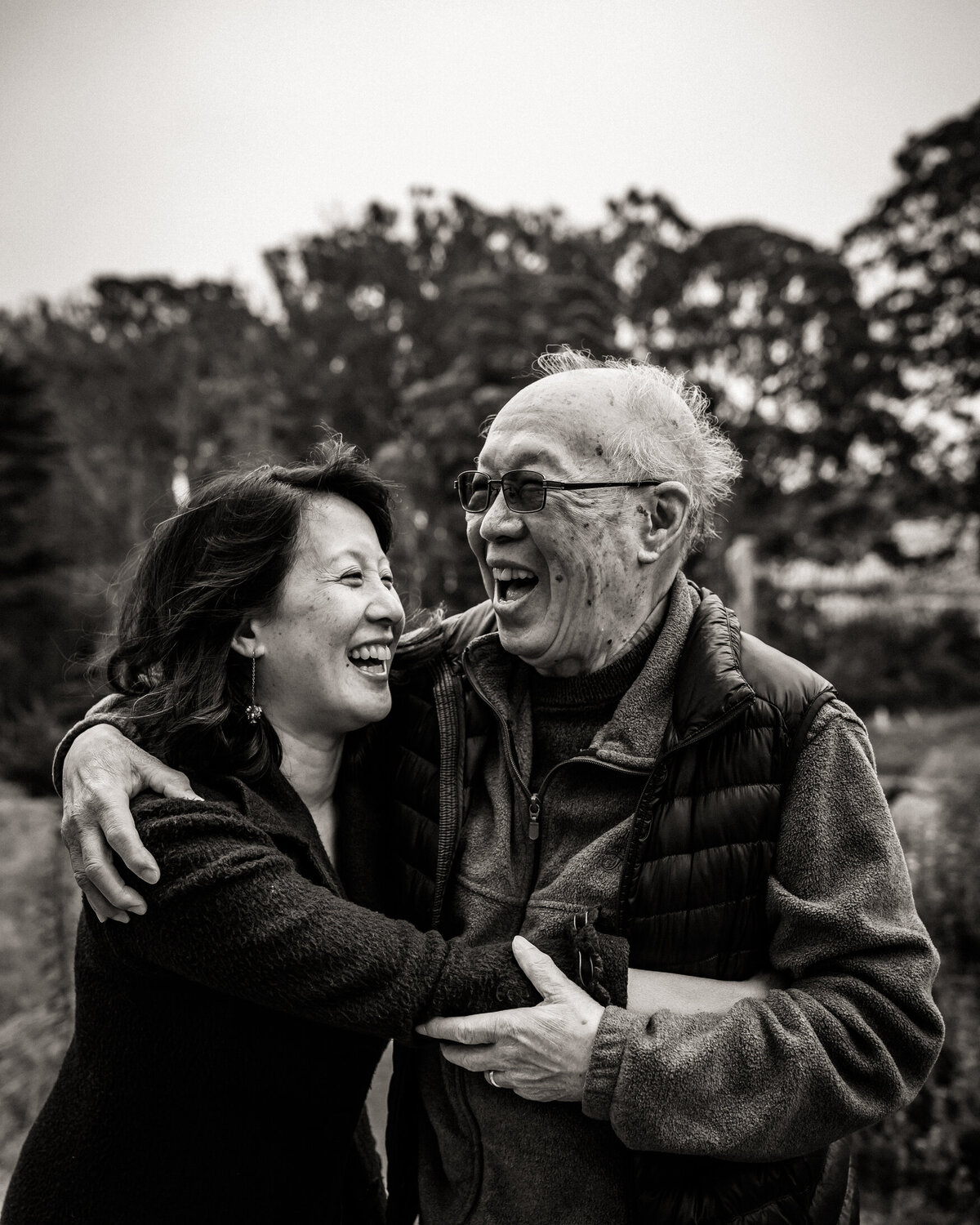 Laughing and embraced portrait of elderly father and daughter