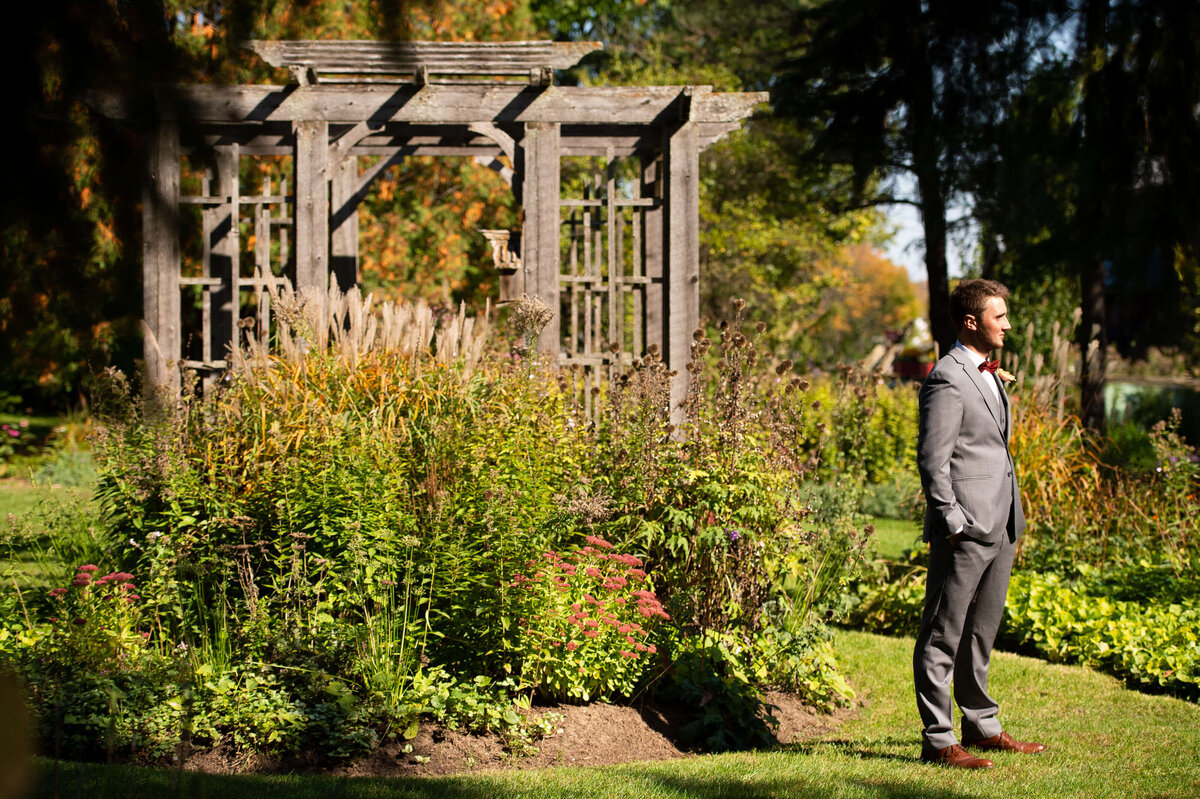 Groom waiting in the Strathmere wedding venue gardens for his bride to appear for first looks