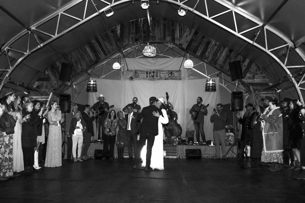 Bride and groom share their first dance on the dance floor with a live band in Beyul Retreat Aspen, Colorado,