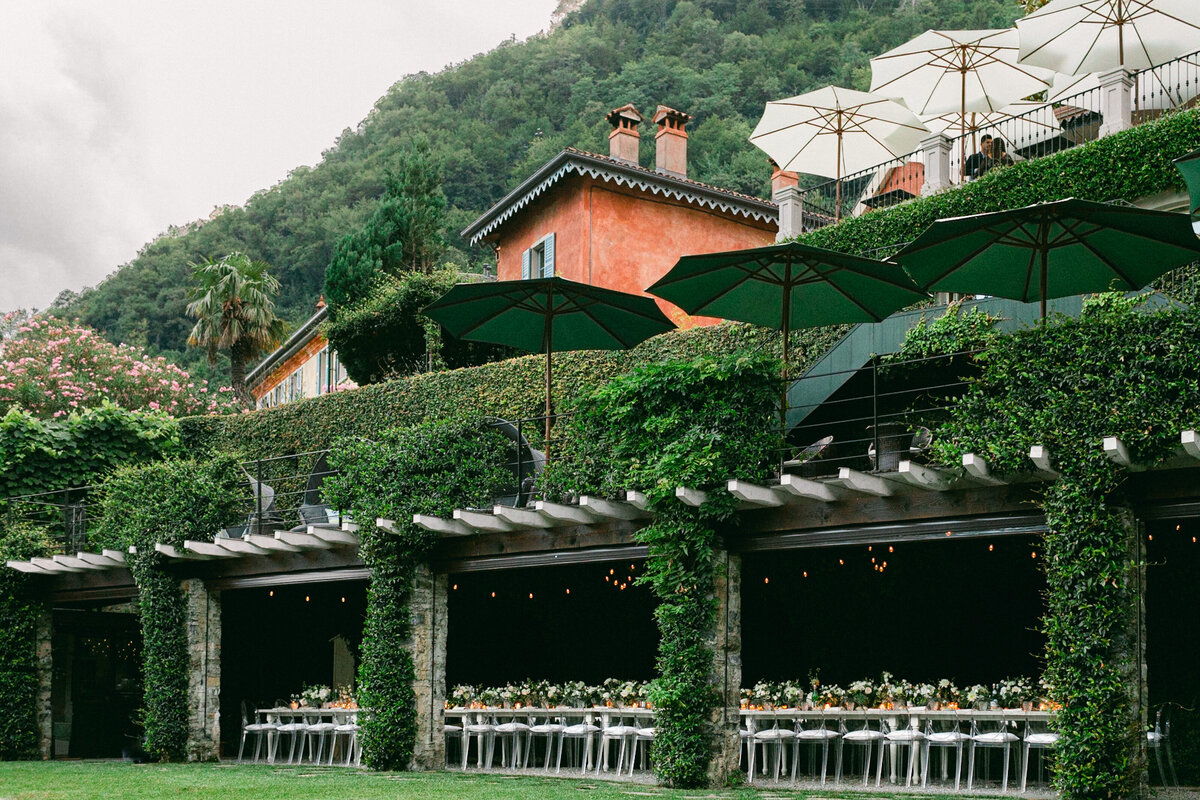 Lake Como Wedding Reception white florals long table under green roof and orange villa