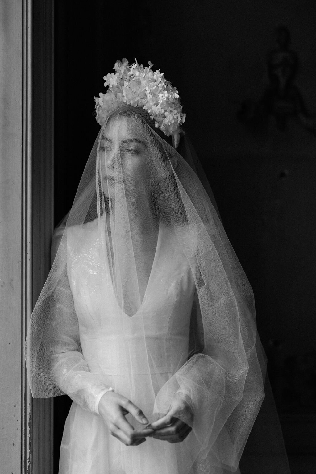 bride wearing veil over face looking out the window