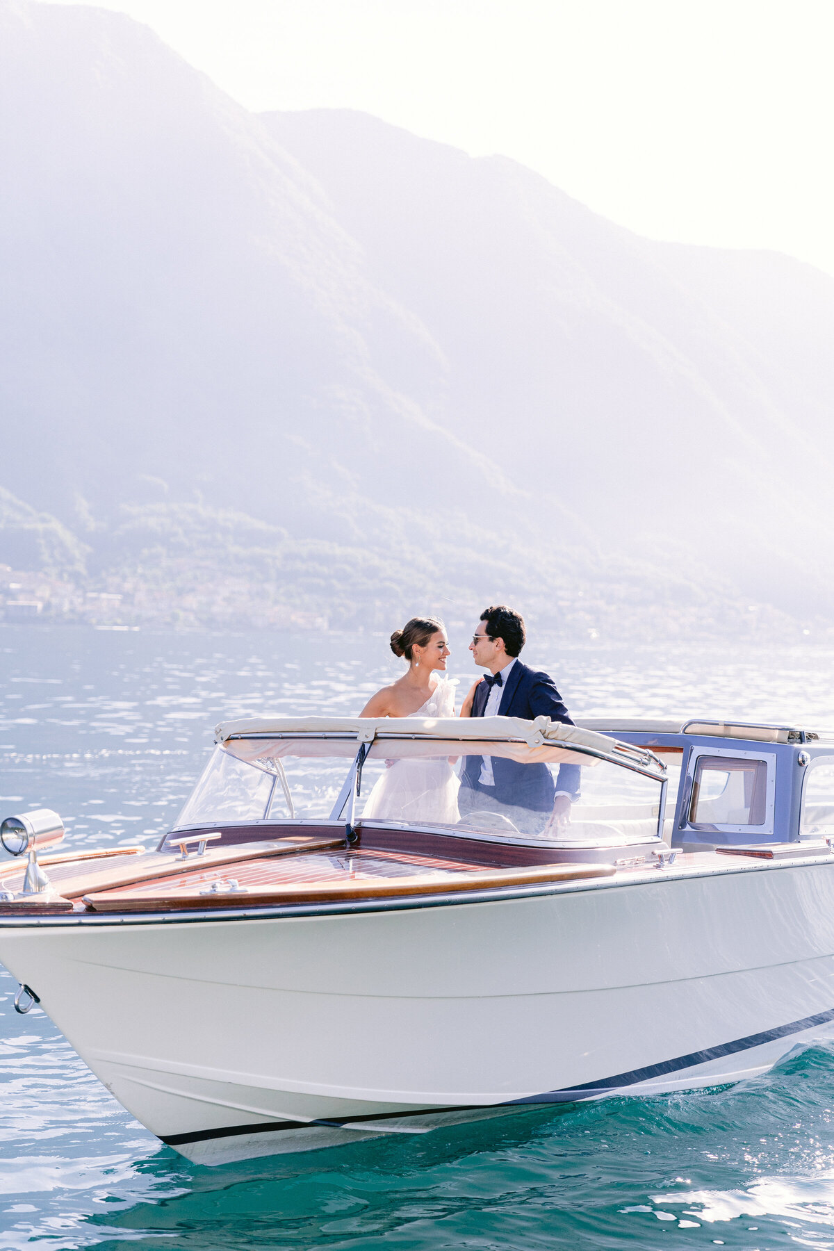 Couple on a private boat on lake como by White Orchid Photography, destination wedding photographer