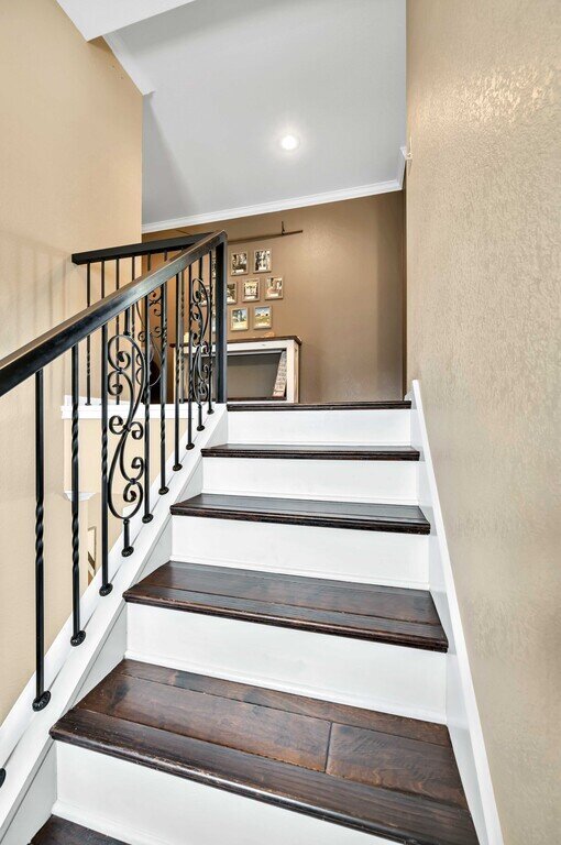 Staircase with beautiful railing in this four-bedroom, four-bathroom vacation rental home and guest house with free WiFi, fully equipped kitchen, firepit and room for 10 in Waco, TX.