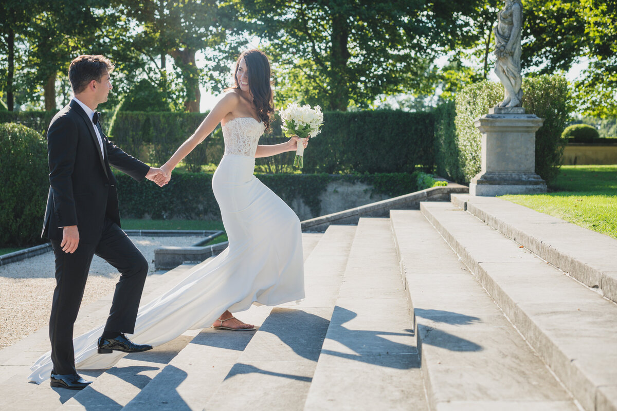 bride and groom going up the steps at Oheka Castle