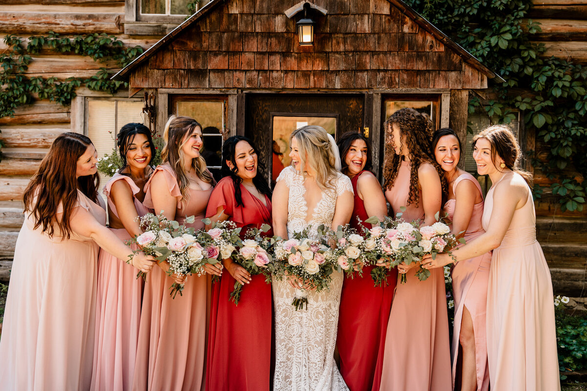 The bride and bridesmaids gather together in front of the rustic house at Brown Family Homestead in Leavenworth, Washington.