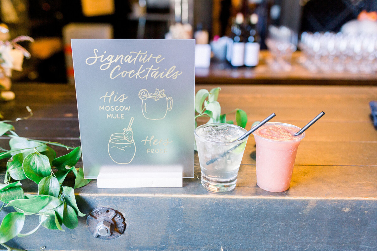 Signature drinks sign with custom drink illustrations, next to the drinks