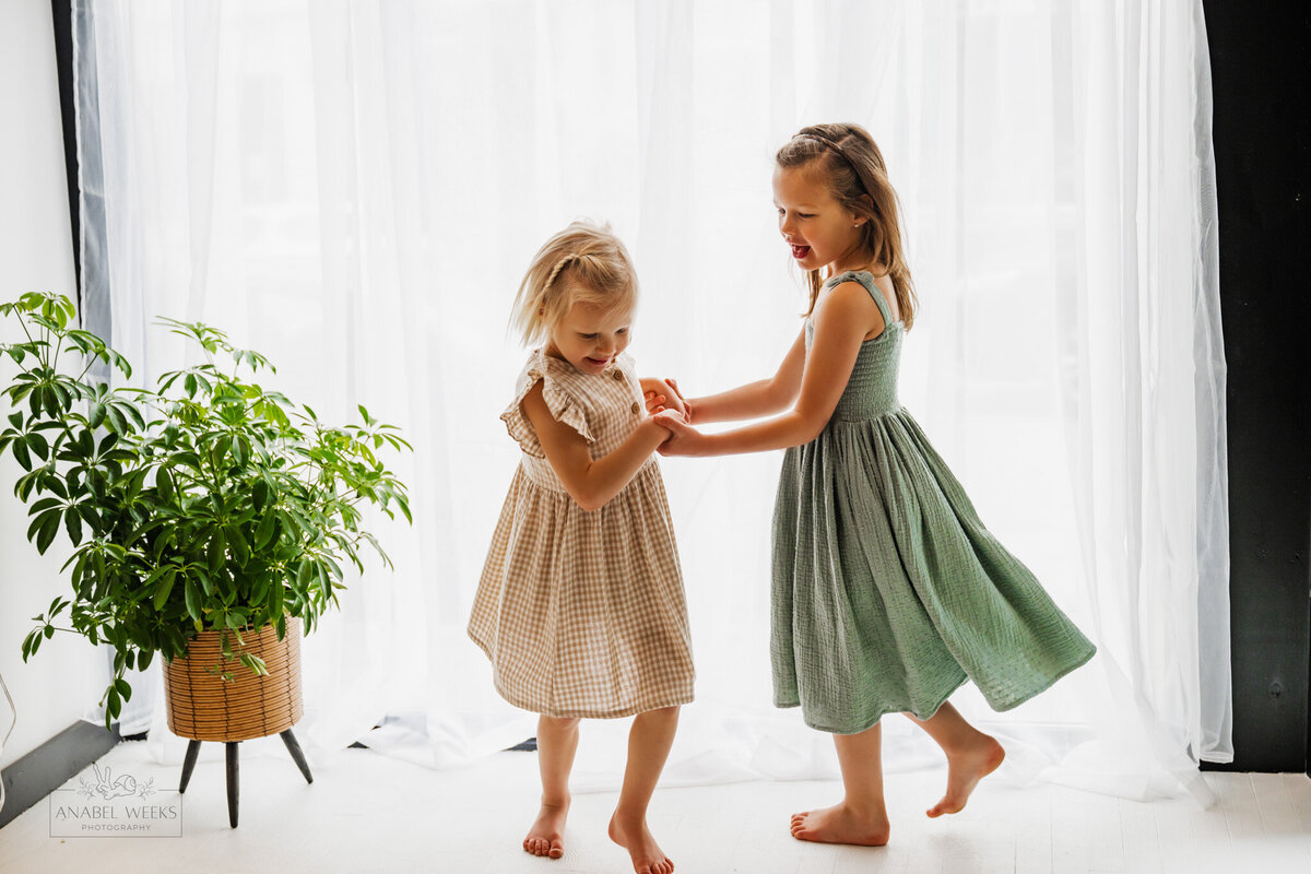 Two young girls dancing in cute dresses
