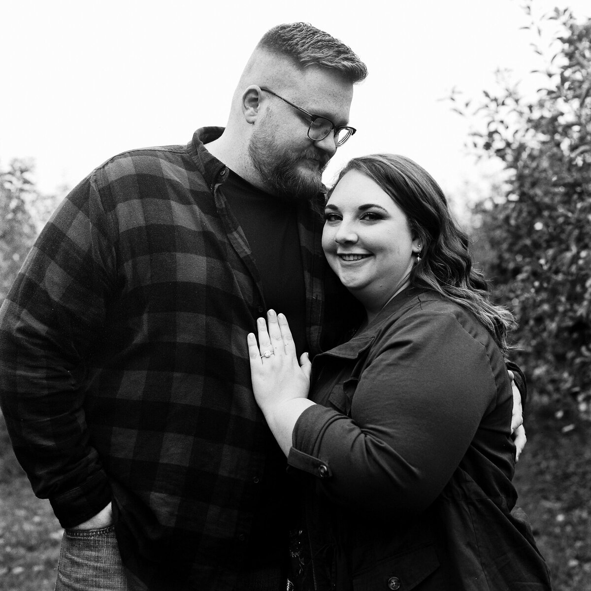 Couple stands for a portrait at apple farm during engagement session