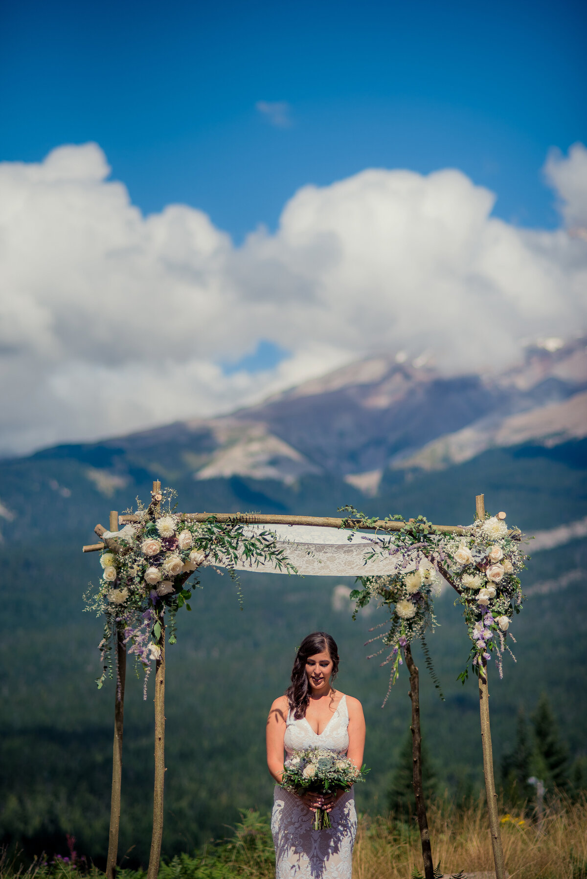 bride under arch with mountain