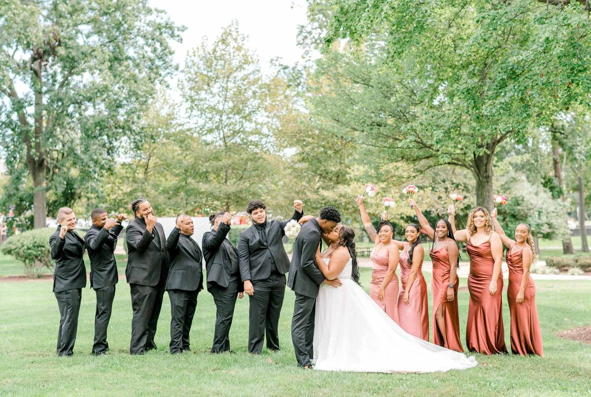 Groomsmen, bridesmaids, and bride and groom standing in a row