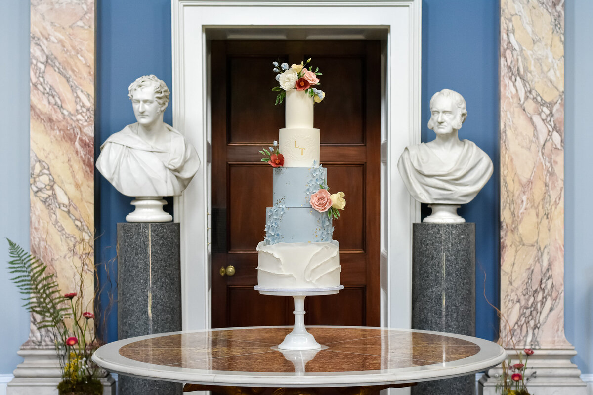 Bridgerton-inspired wedding pale blue wedding cake with sugar flowers ruffles and monogram
