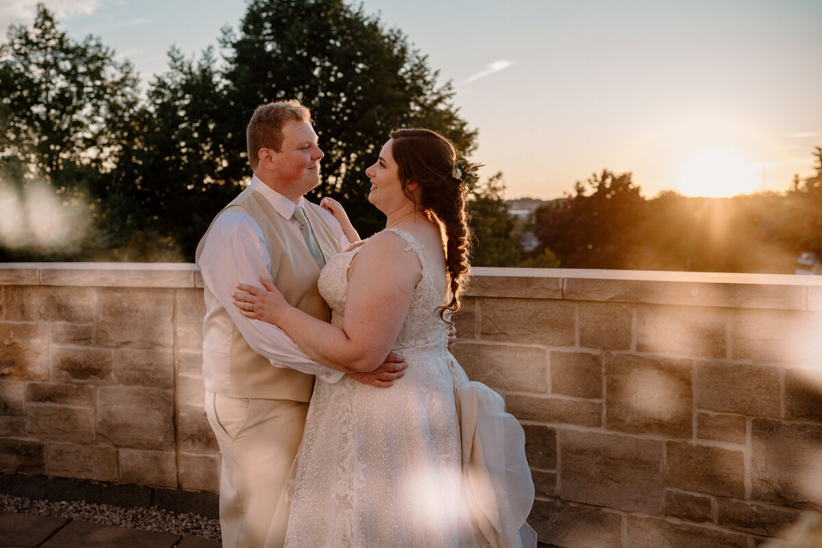 bride and groom dance on the patio while the sunsets