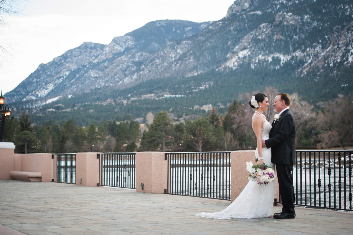 Bride and groom posing outside the Lake Terrace with a mountain background