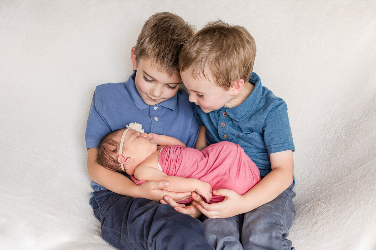 my sons holding their baby sister