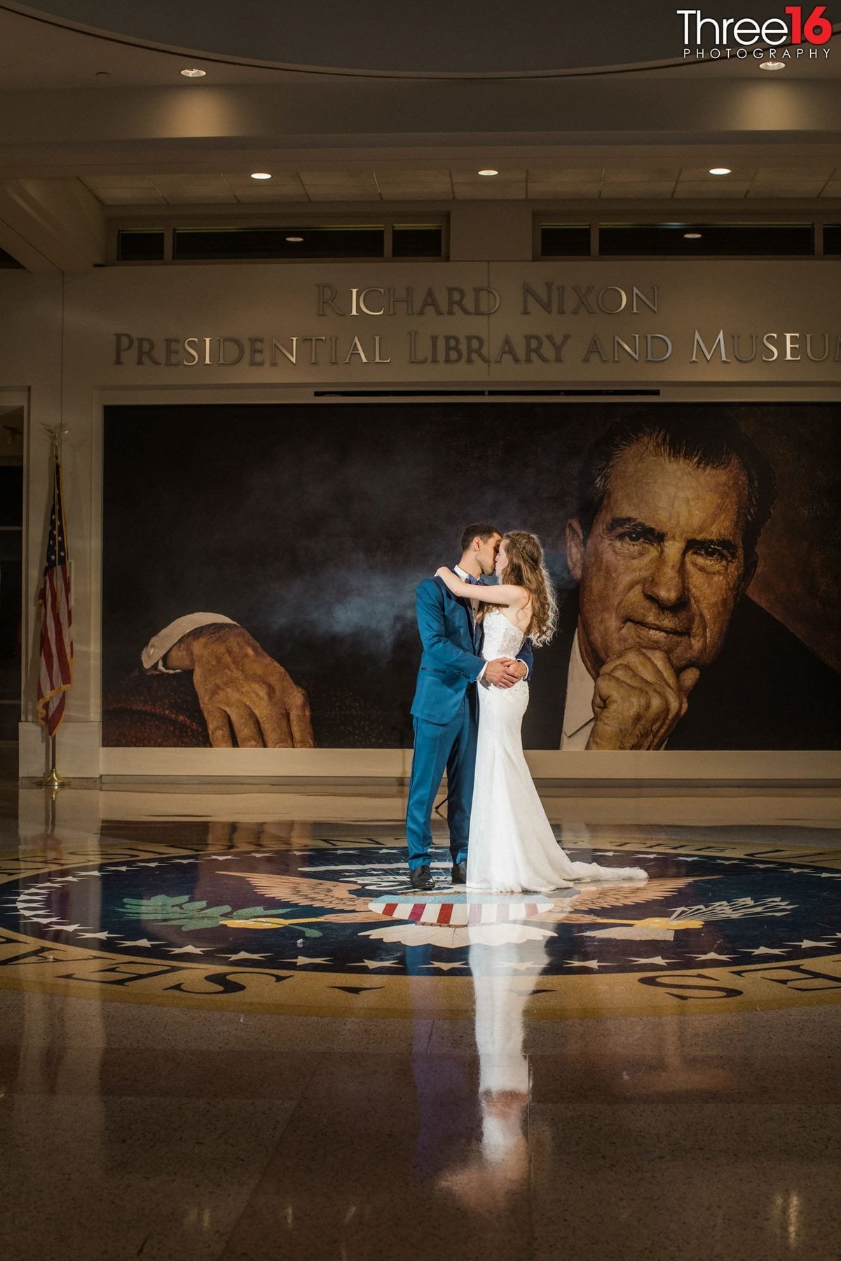 Bride and Groom kiss in the middle of the Richard Nixon Library lobby