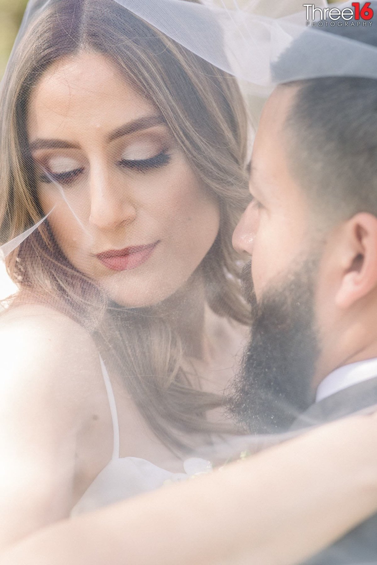 Intimate moment between Bride and Groom as they pose underneath her veil