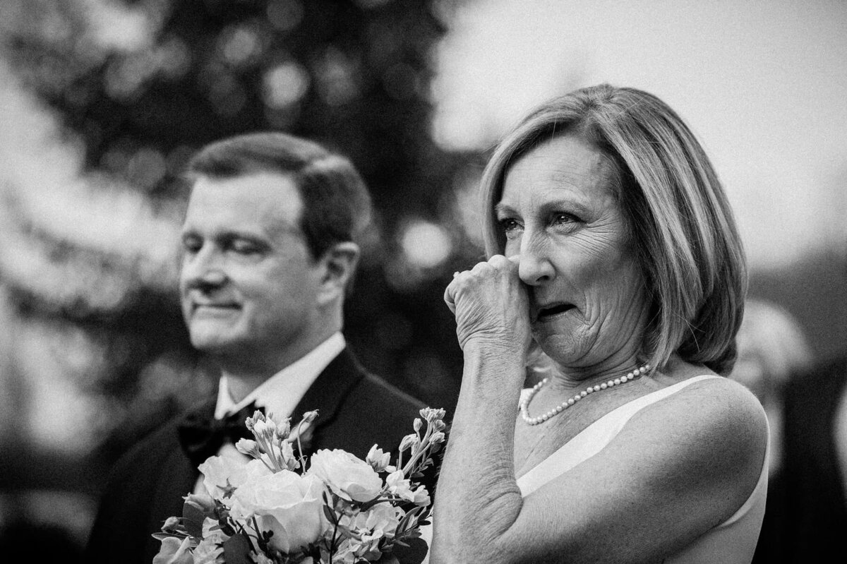 A bride wiping a tear away during a wedding cermeony.
