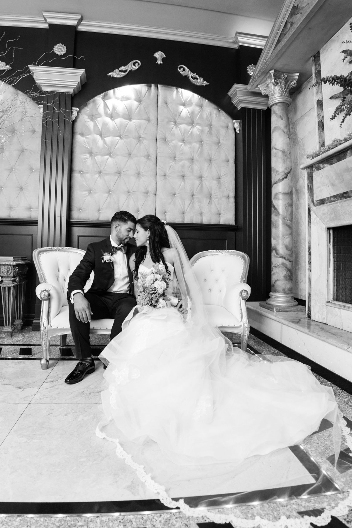 Black and white photo of bride and groom sitting on a sofa at The Sands