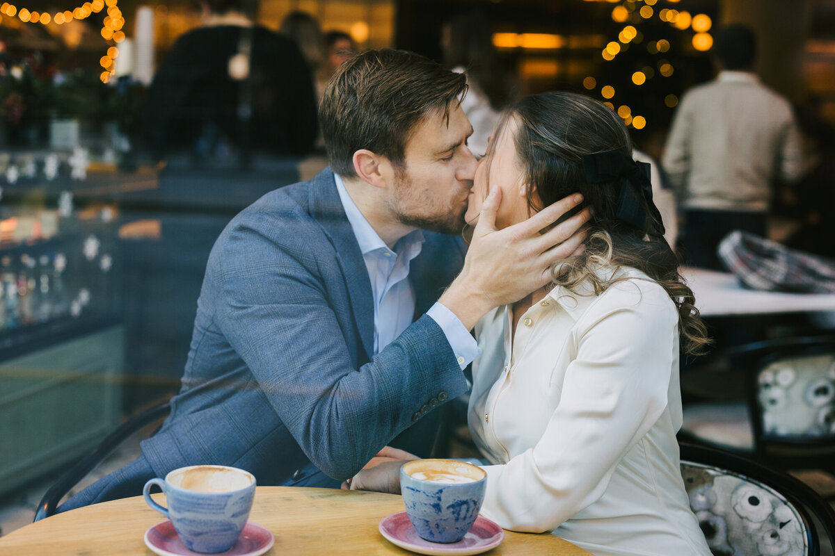A beautiful engagement photo captured by Chicago engagement photographer Ashley Biess of a couple kissing in a local cafe