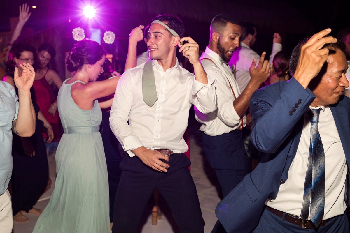 Groom dancing with guests at wedding in Cancun