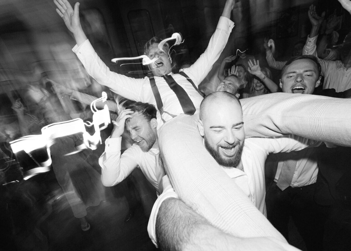 chloe-winstanley-weddings-grittleton-house-groom-crowdsurfing-black-white
