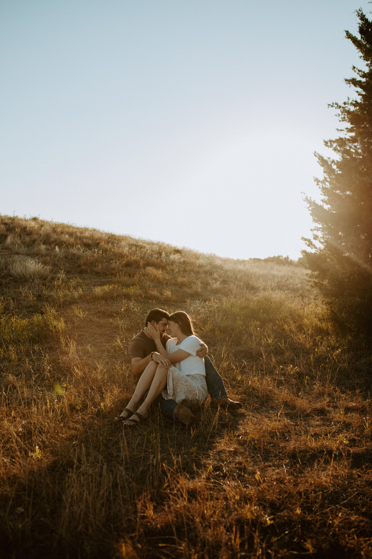 Man and woman sitting embracing each other with at golden hour