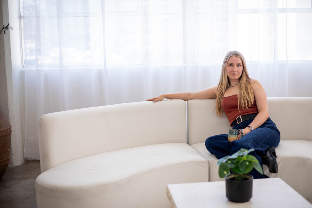laptop on a table next to a cup of milky coffee