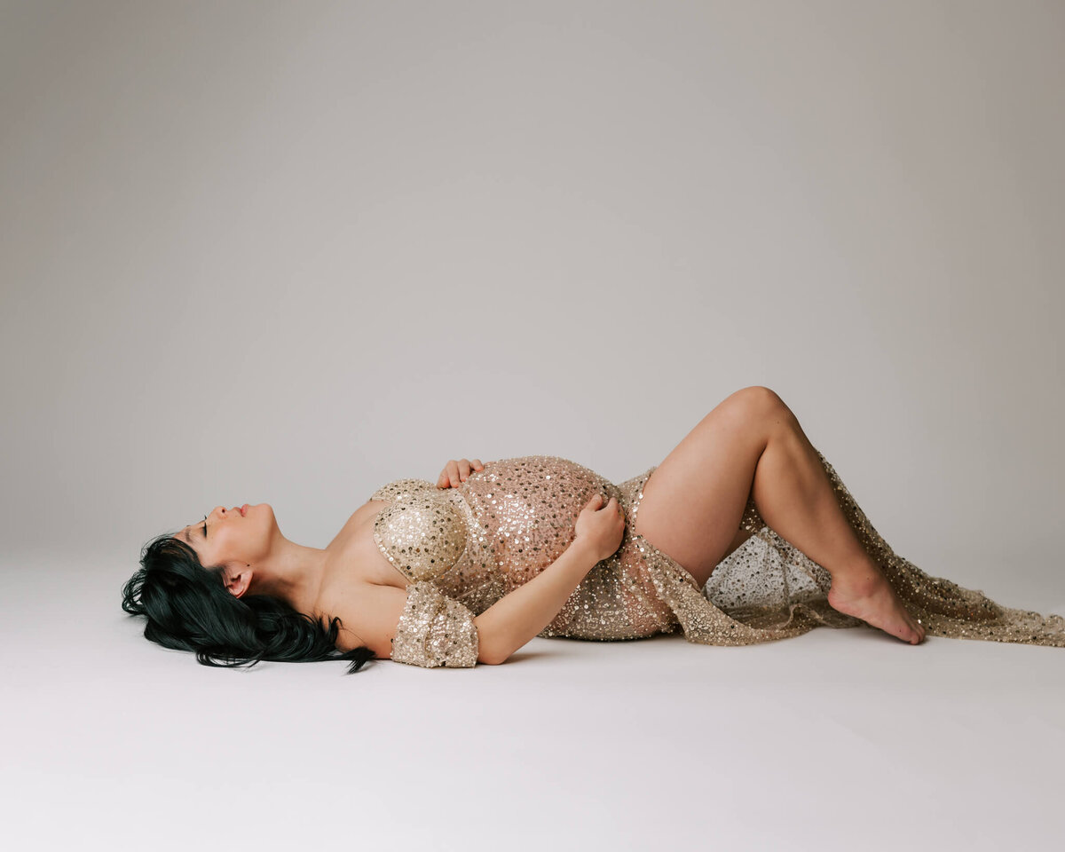 Pregnant mom laying down in maternity portrait in Portland studio