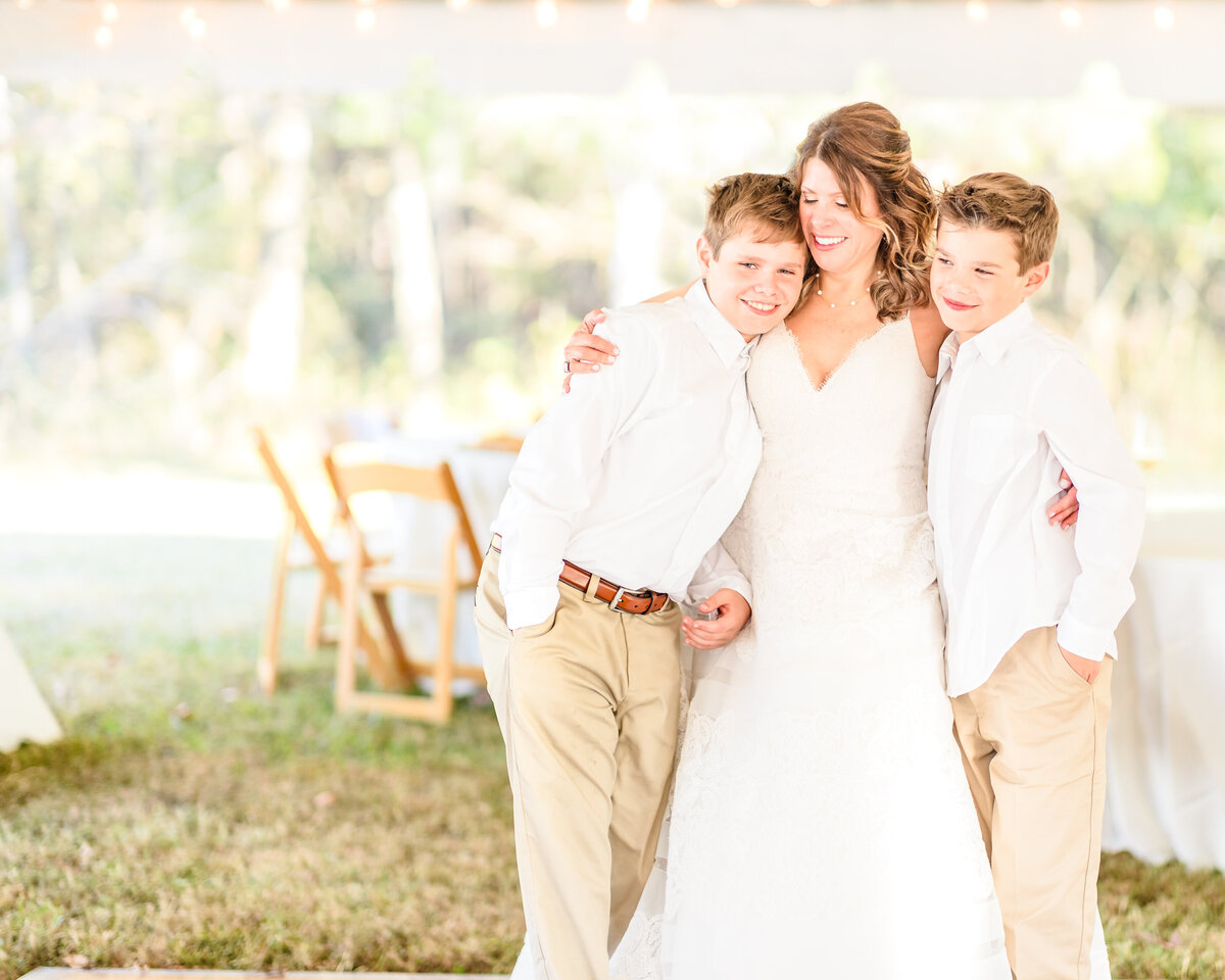 Mother and two sons hugging at outdoor fall  wedding