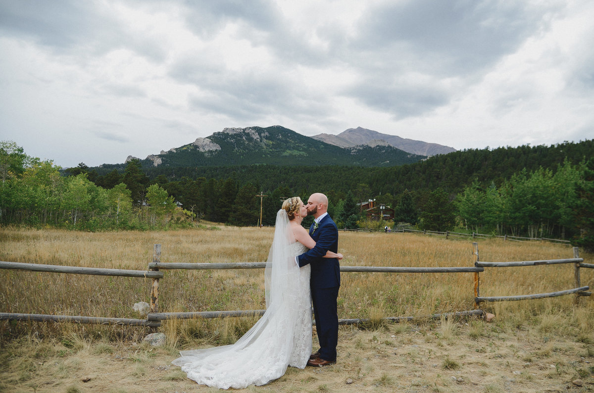 bride and groom kissing infront of rocky mountains