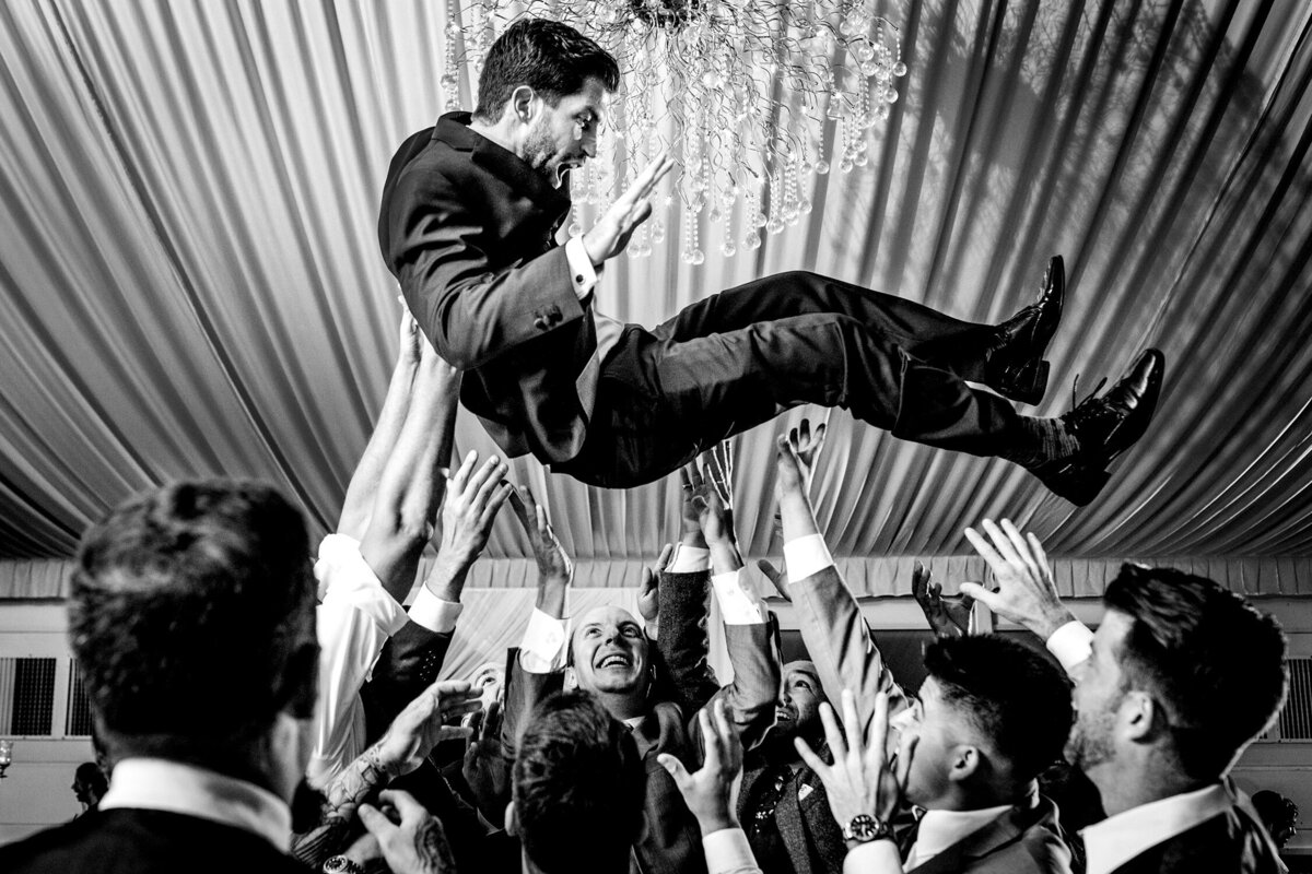 A groom is thrown in the air during a Galleria Marchetti wedding.