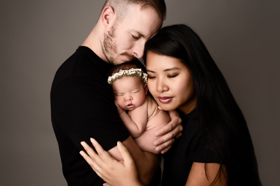 Lansing Newborn Photography Mom and Dad Snuggling Baby by For the Love of Photography