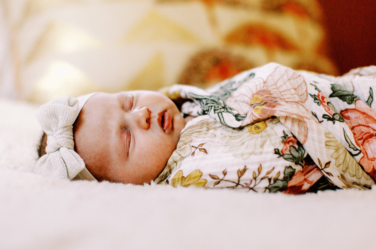 sleeping newborn baby girl with bow in hair