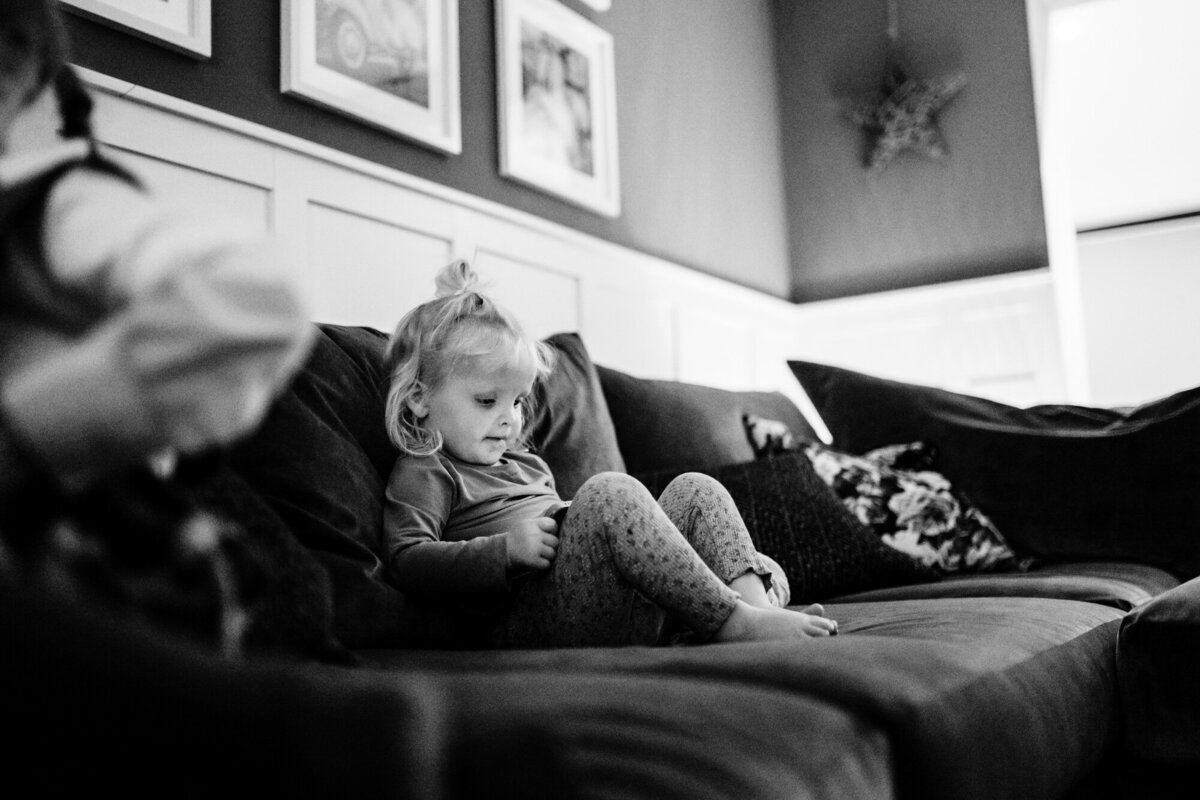 Little girl on sofa with tablet during at home family photoshoot