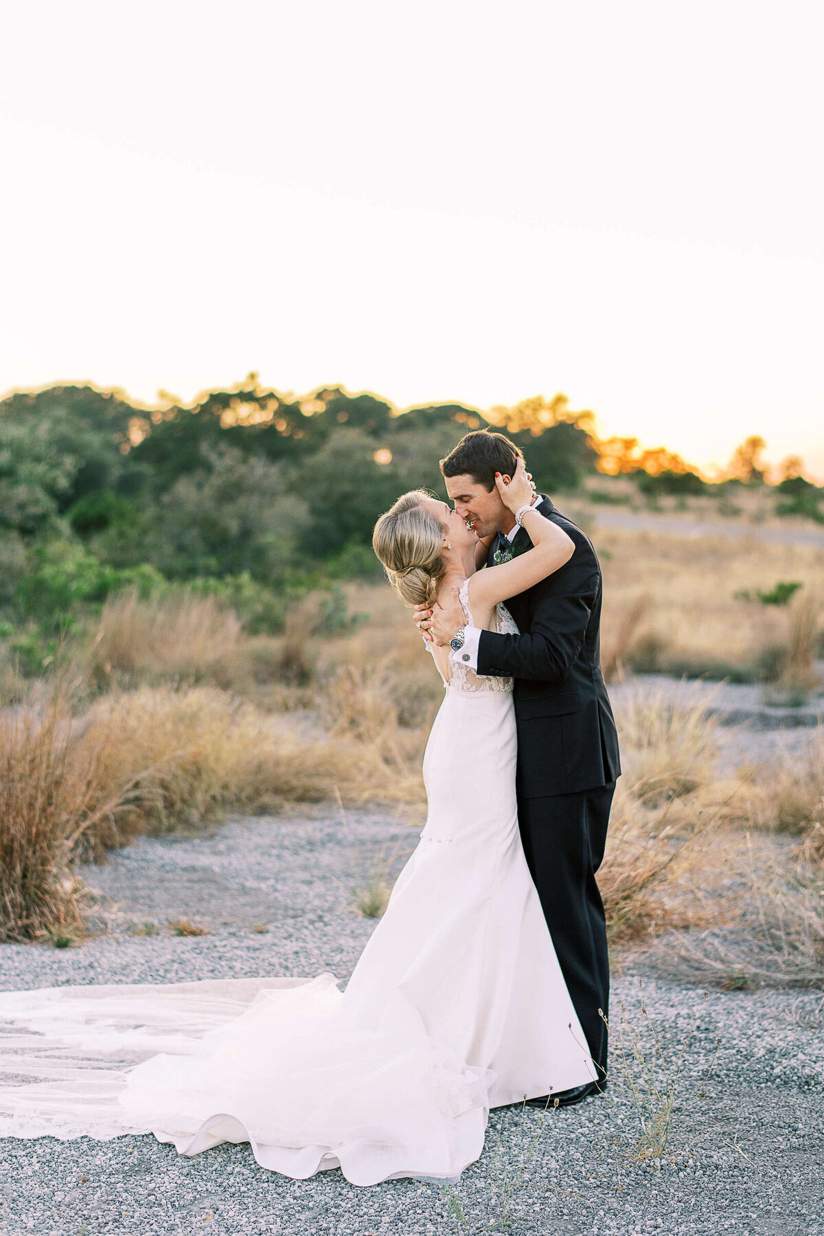 Bride and groom embrace in desert hill country