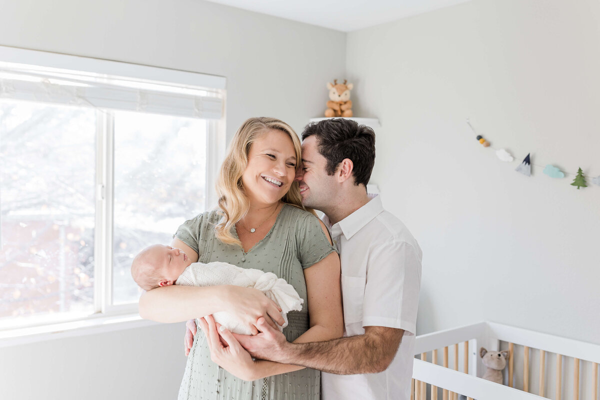 Beautiful couple laughing  in Folsom home during their maternity photoshoot by Caroline Bendel