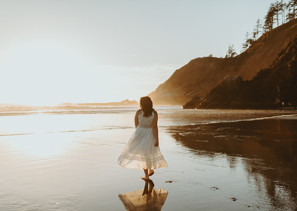 girl dancing on beach at sunset in white dress