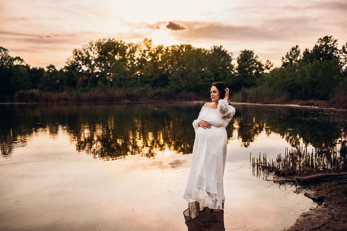 pregnant woman in a lake at sunset