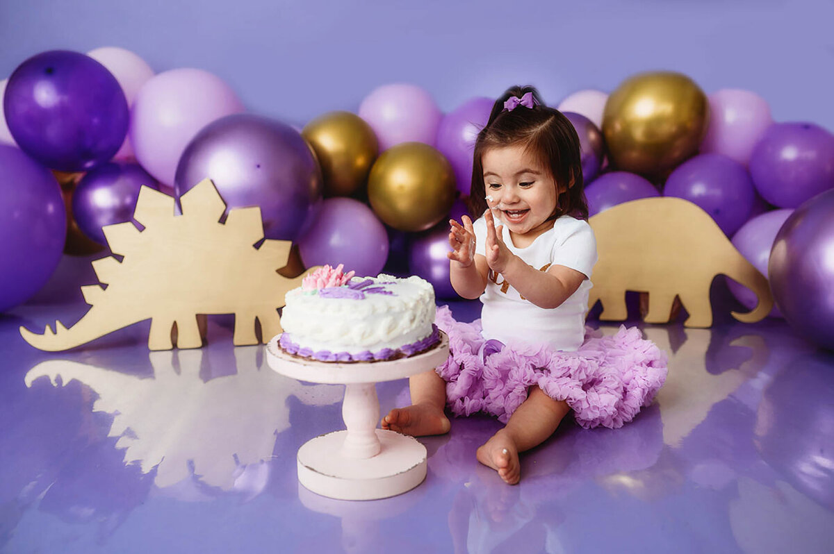 Baby claps during her Cake Smash photoshoot at Asheville, NC photo studio.