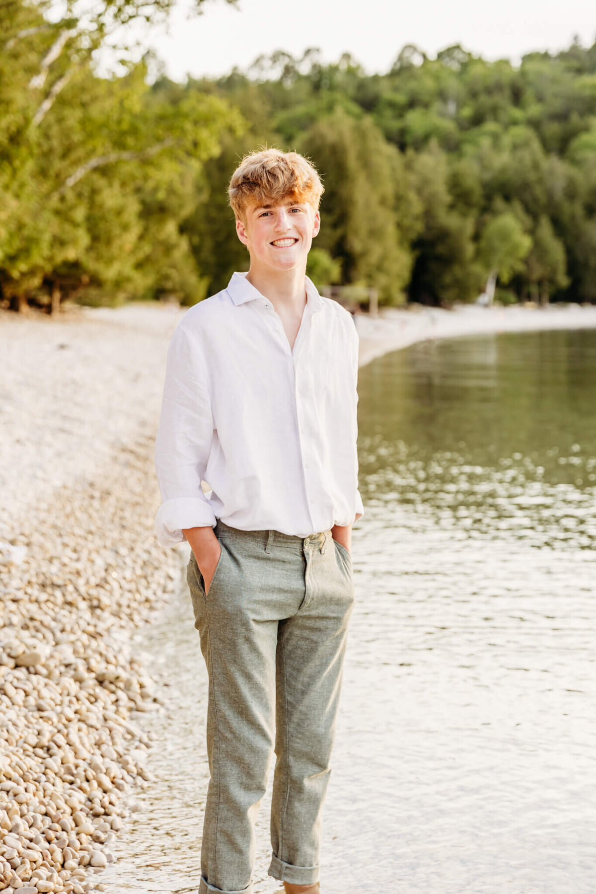 high school boy standing with hands in pockets in the lake